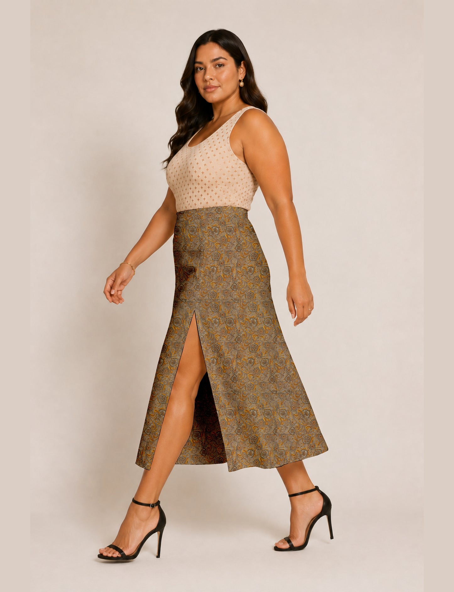 Woman wearing a yellow and black micro patterned A-line skirt with front slit, paired with beige sleeveless top and black