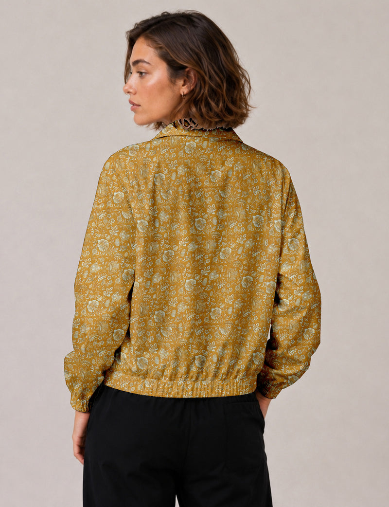Brown floral bomber jacket with front zipper, elastic cuffs and hem, hanging on white hanger, red floral inner lining visible