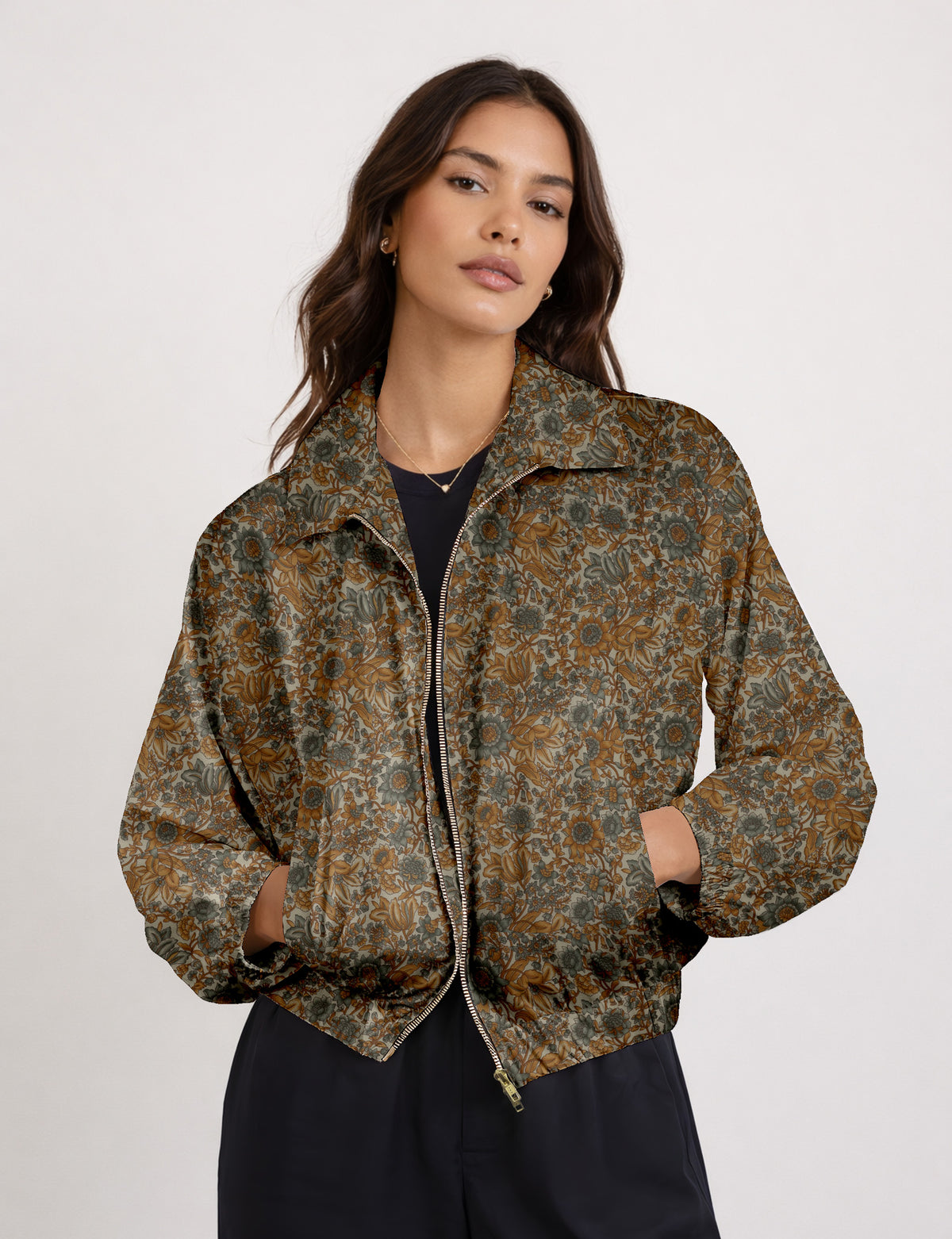 Woman wearing a yellow floral bomber jacket with front zipper, elastic cuffs, and side pockets, shown from front view