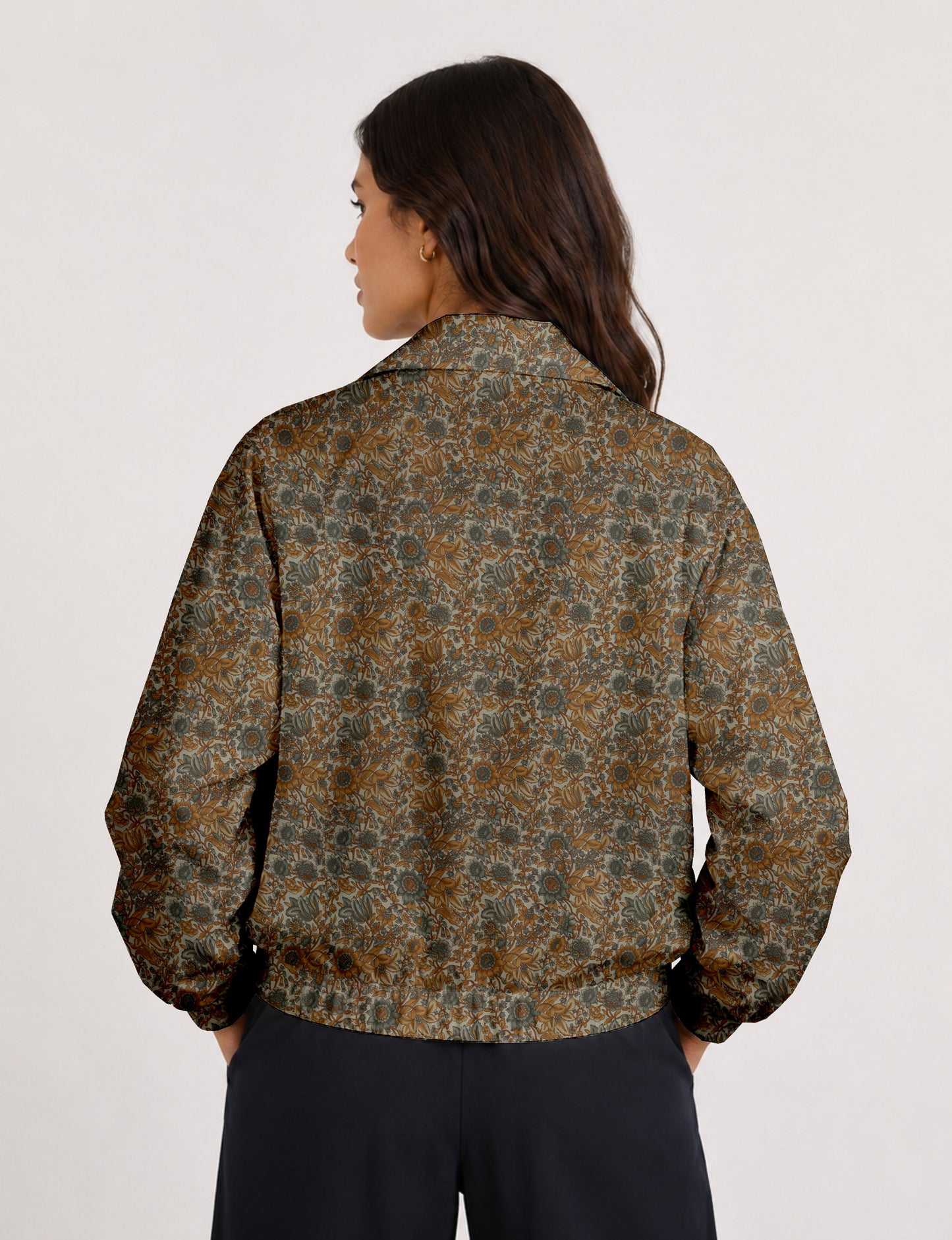Brown floral bomber jacket with front zipper, elastic cuffs and hem, hanging on white hanger, red floral inner lining visible