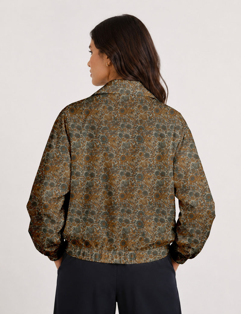 Brown floral bomber jacket with front zipper, elastic cuffs and hem, hanging on white hanger, red floral inner lining visible