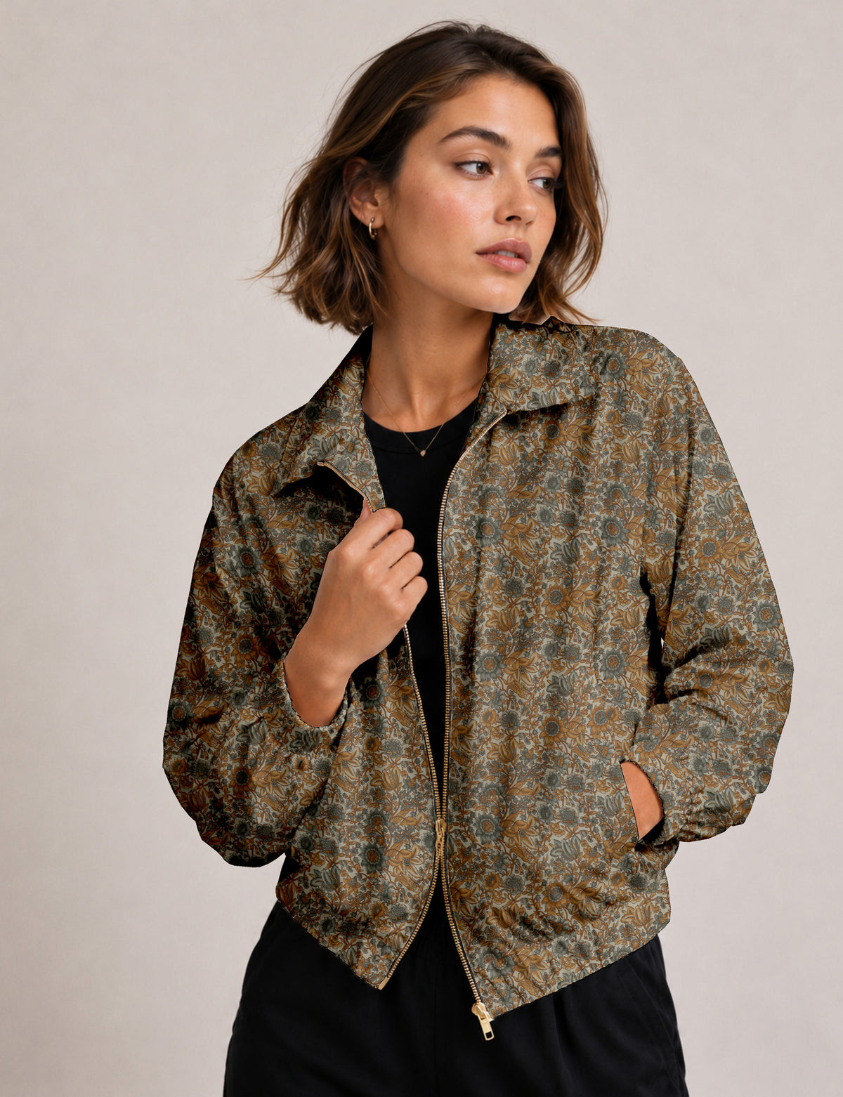 Woman wearing a yellow floral bomber jacket with front zipper, elastic cuffs, and side pockets, shown from front view