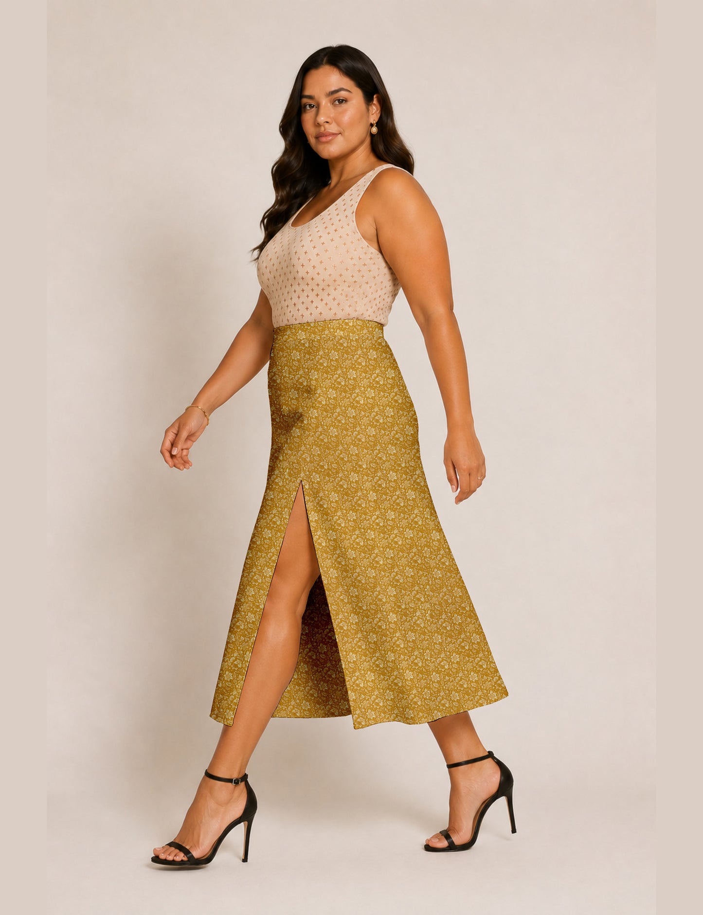 Woman wearing a yellow and black micro patterned A-line skirt with front slit, paired with beige sleeveless top and black