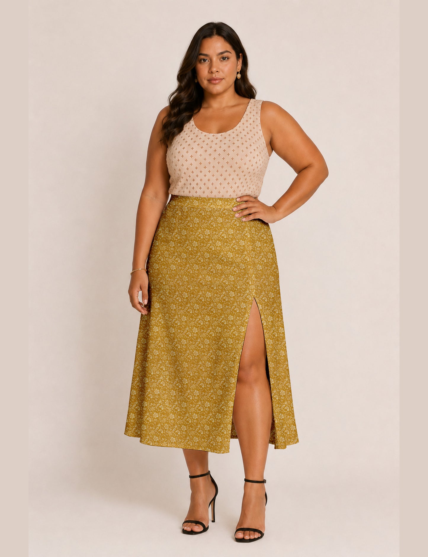 Woman wearing a yellow and black micro patterned A-line skirt with front slit, paired with beige sleeveless top and black