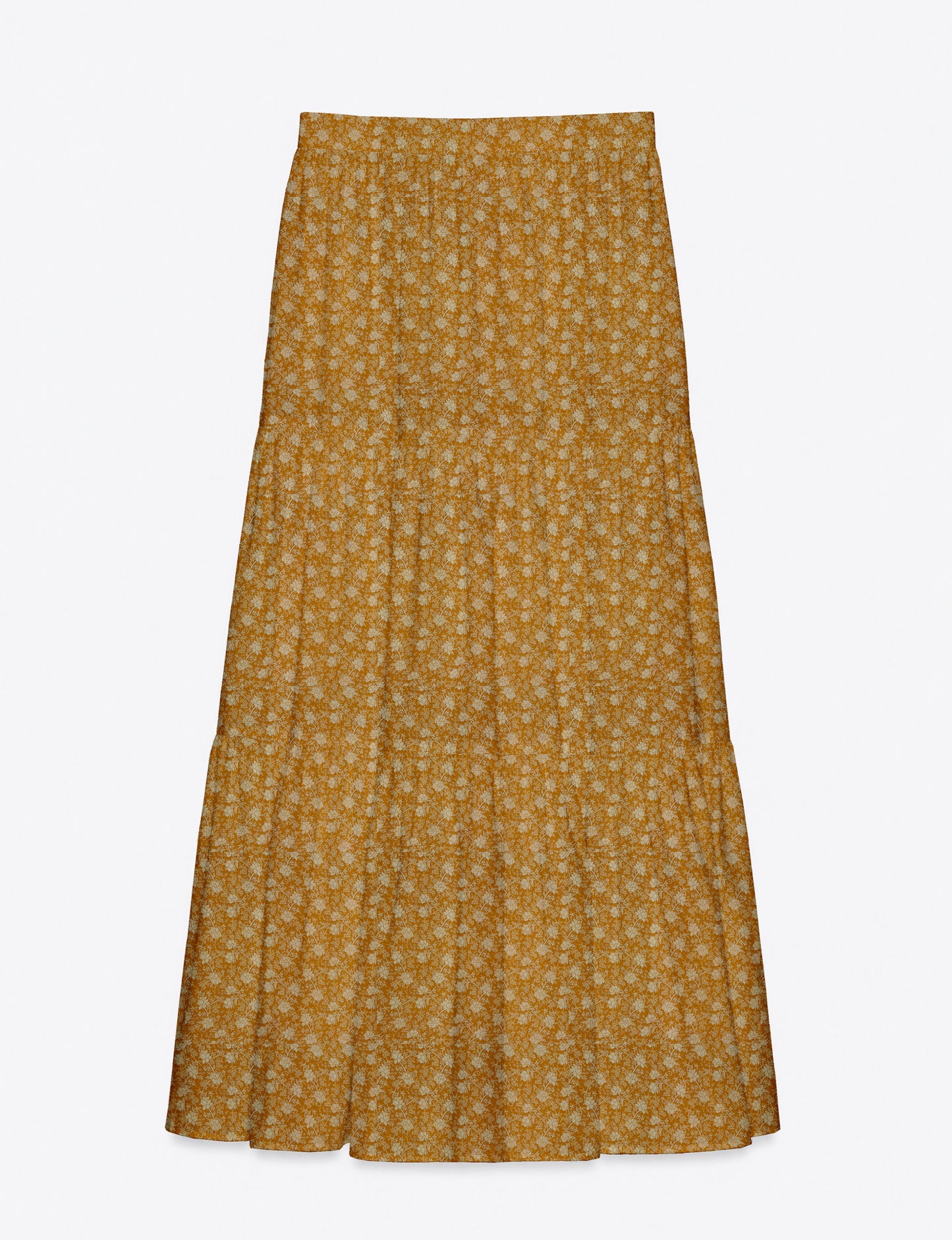 Woman wearing a yellow midi tiered skirt with a small geometric pattern, shown from the back, paired with beige top and