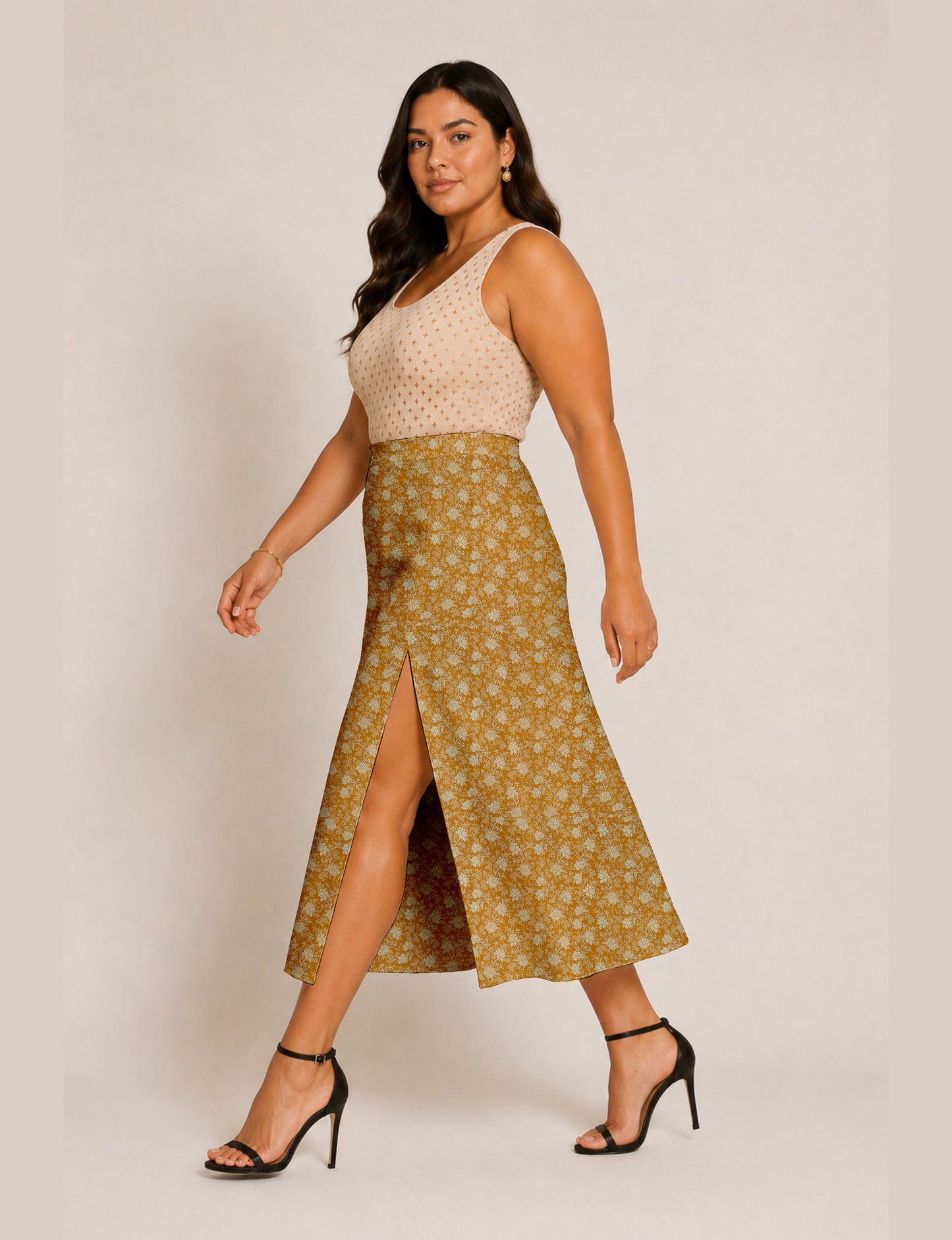 Woman wearing a yellow and black micro patterned A-line skirt with front slit, paired with beige sleeveless top and black