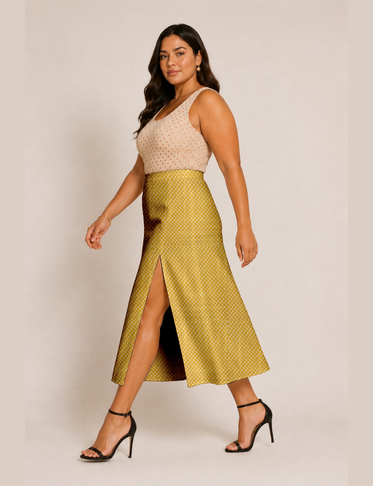 Woman wearing a yellow and black micro patterned A-line skirt with front slit, paired with beige sleeveless top and black