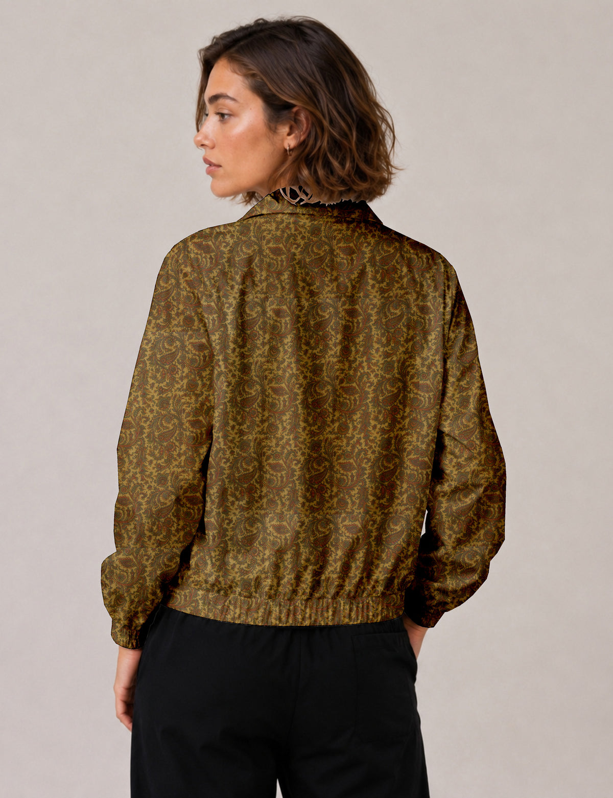 Woman wearing a yellow floral bomber jacket with front zipper, elastic cuffs, and side pockets, shown from front view