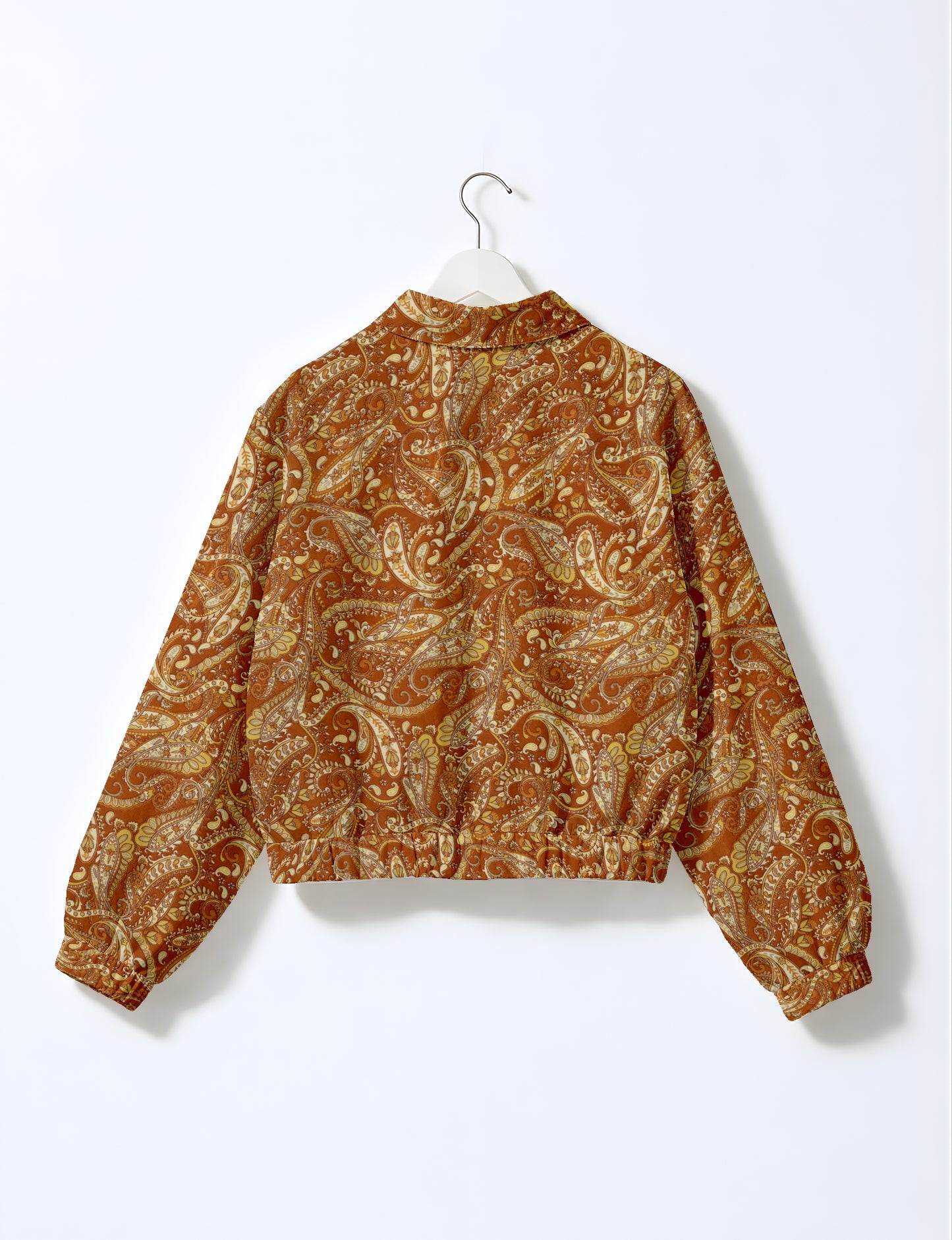 Yellow and brown paisley patterned bomber jacket with elastic cuffs and waistband, shown from back on white hanger