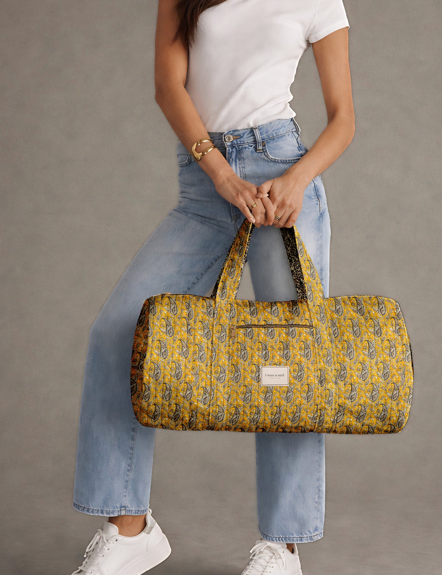 Brown paisley quilted bowling bag with dual handles, front zipper pocket, and "I was a sari" label on front side