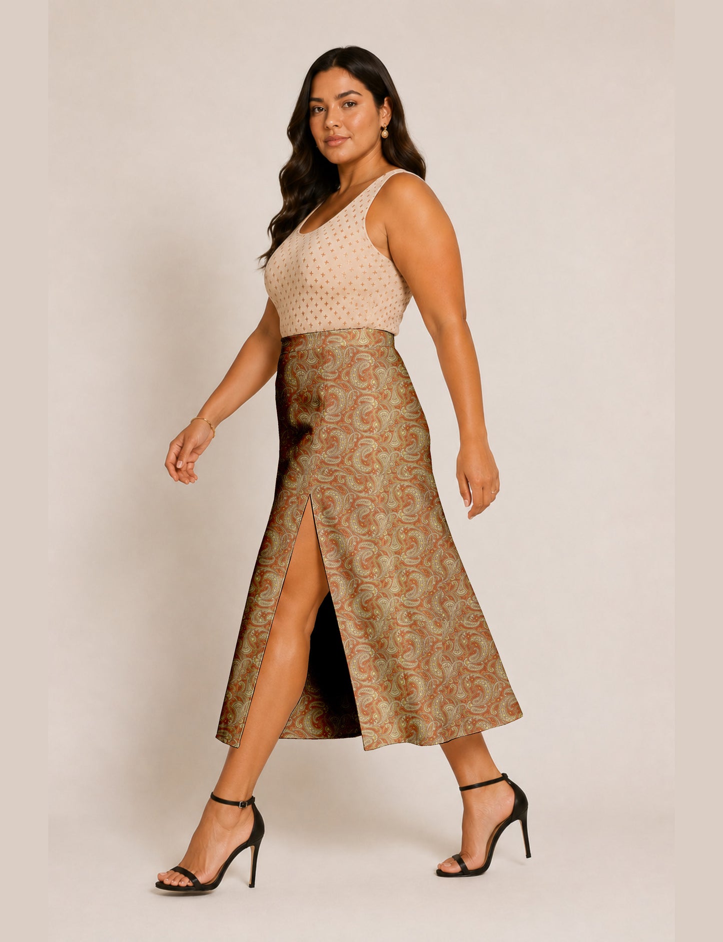 Woman wearing a yellow and black micro patterned A-line skirt with front slit, paired with beige sleeveless top and black