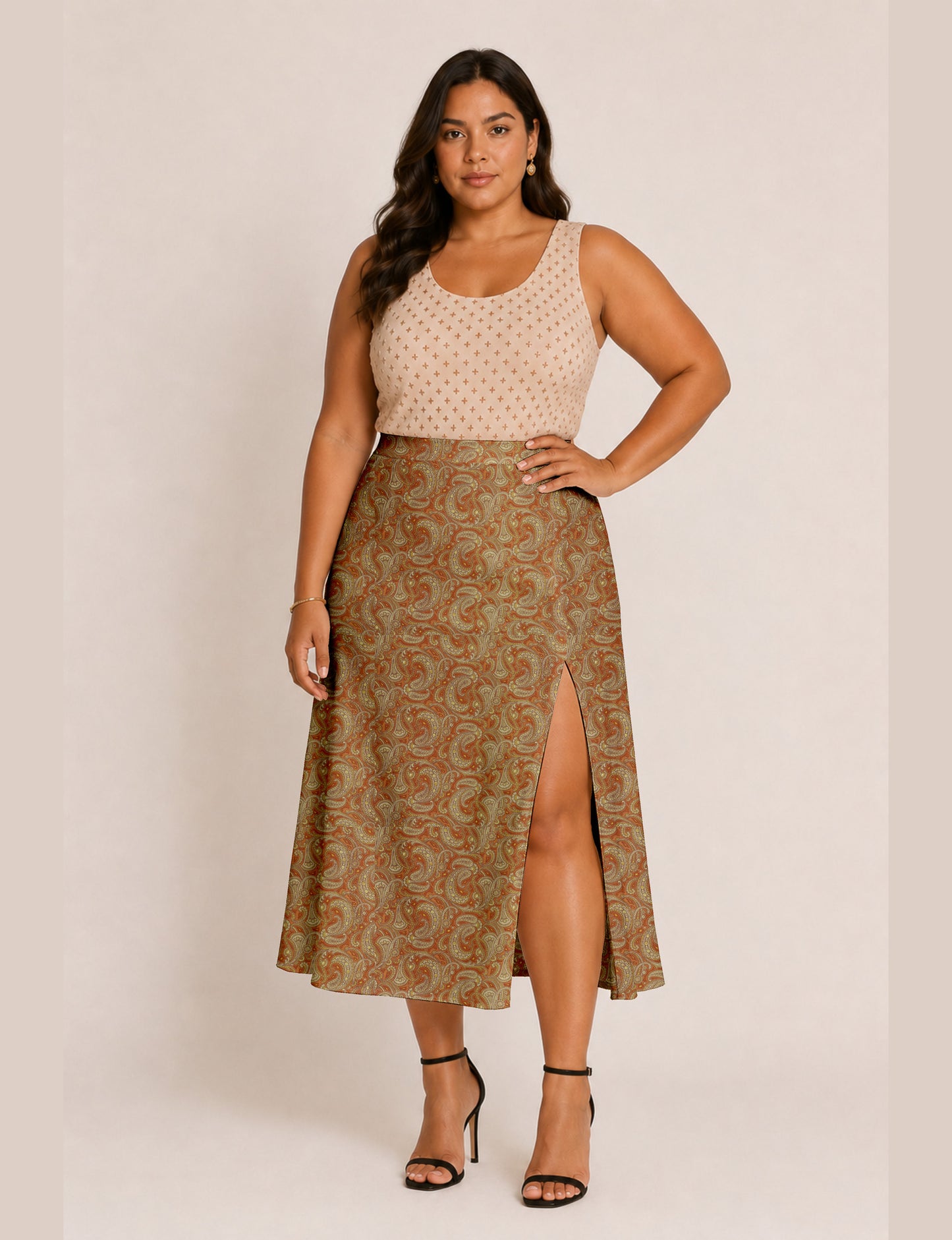 Woman wearing a yellow and black micro patterned A-line skirt with front slit, paired with beige sleeveless top and black