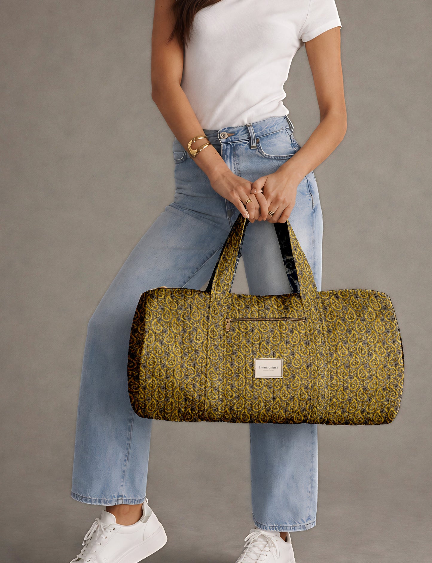 Brown paisley quilted bowling bag with dual handles, front zipper pocket, and "I was a sari" label on front side