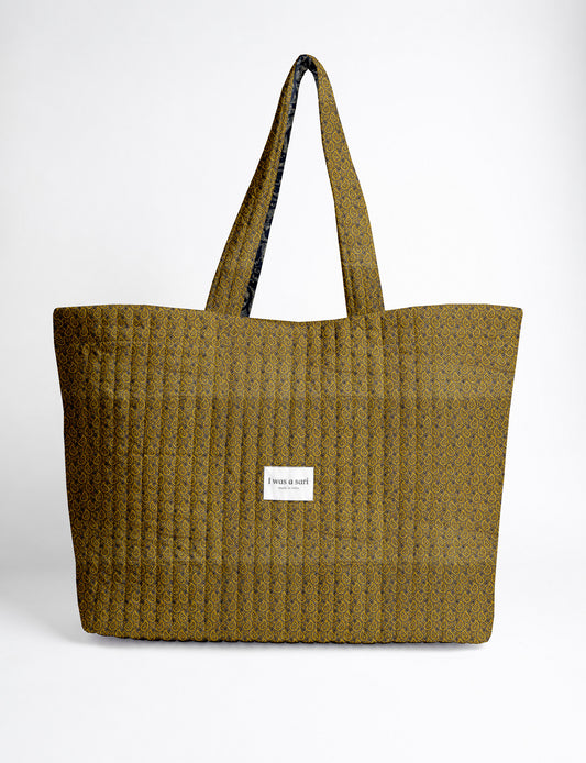 Quilted yellow tropical patterned beach bag with long handles and white label reading "I was a sari" front view