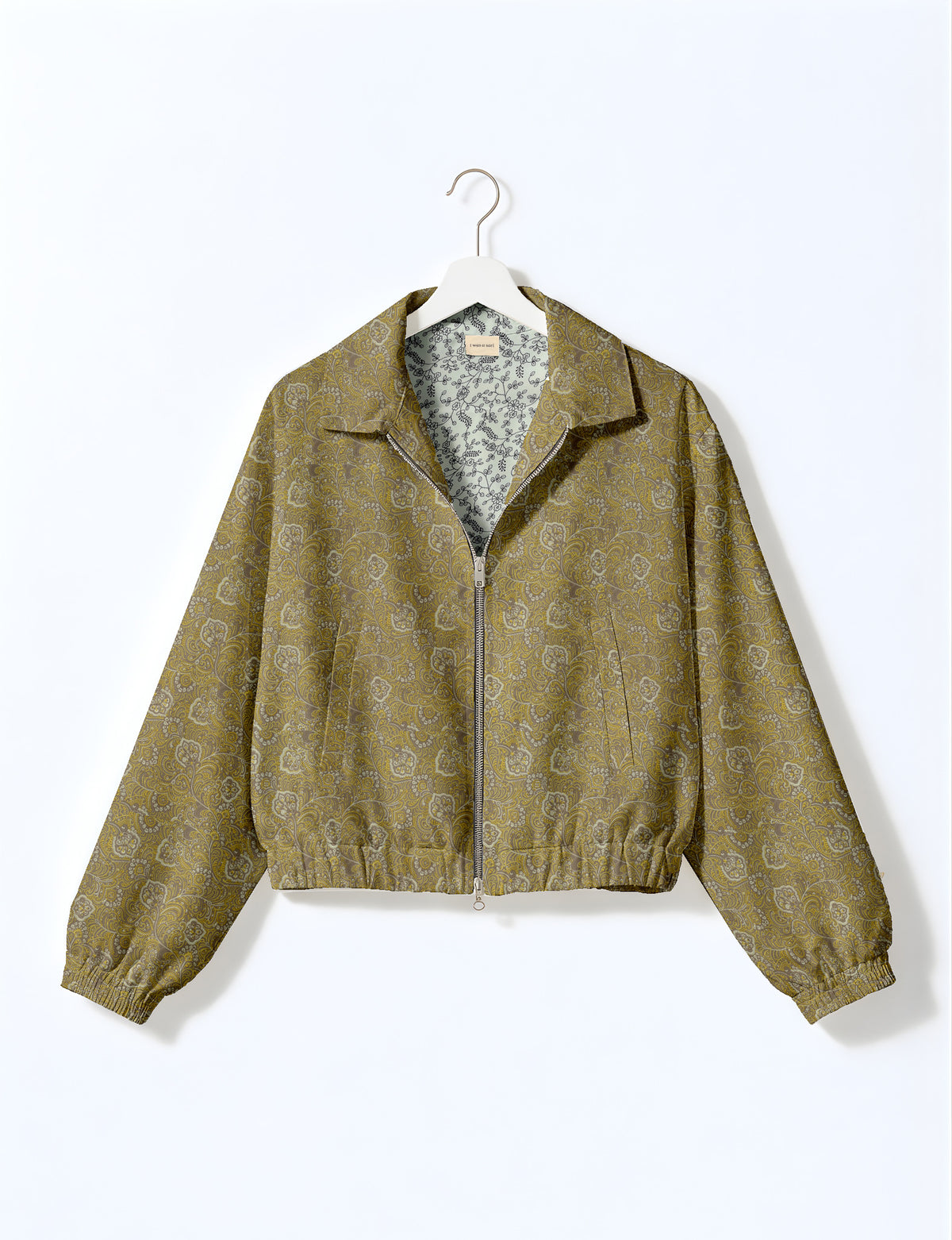Brown floral bomber jacket with front zipper, elastic cuffs and hem, hanging on white hanger, red floral inner lining visible