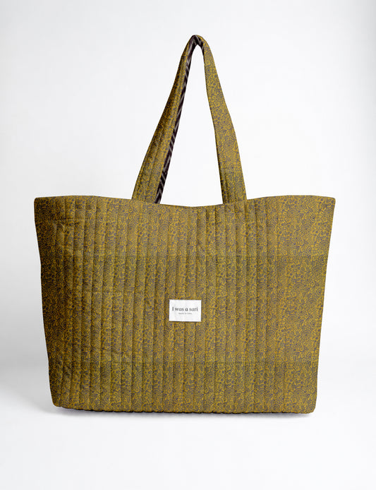 Large quilted beach bag with spacious rectangular design, reinforced shoulder straps, and open-top construction for everyday use and travel.