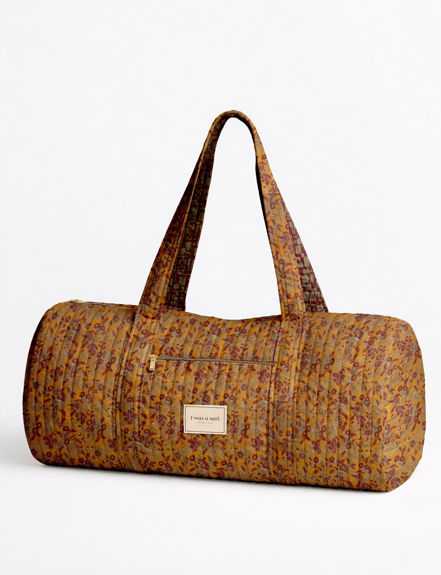 Beige quilted bowling bag with micro floral pattern, front zipper pocket, and dual handles with striped inner lining