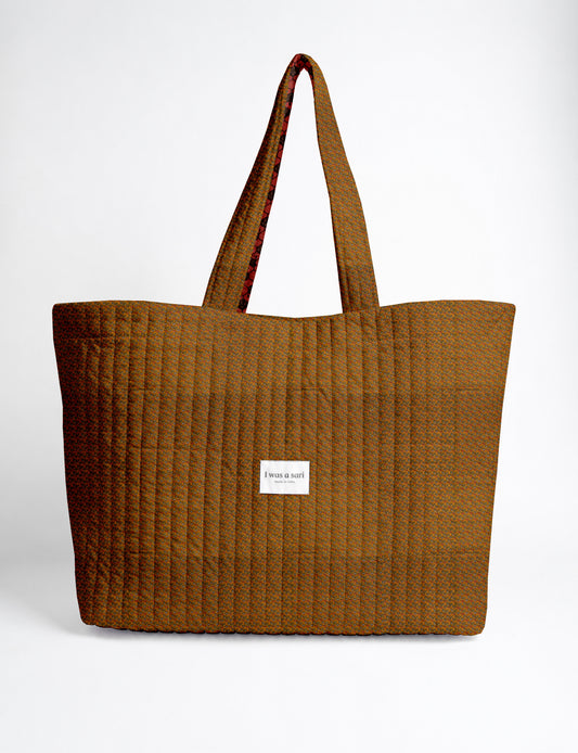 Large quilted beach bag with spacious rectangular design, reinforced shoulder straps, and open-top construction for everyday use and travel.