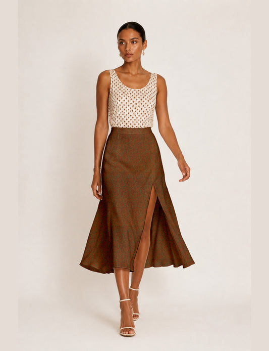 Woman wearing a yellow and black micro patterned A-line skirt with front slit, paired with beige sleeveless top and black