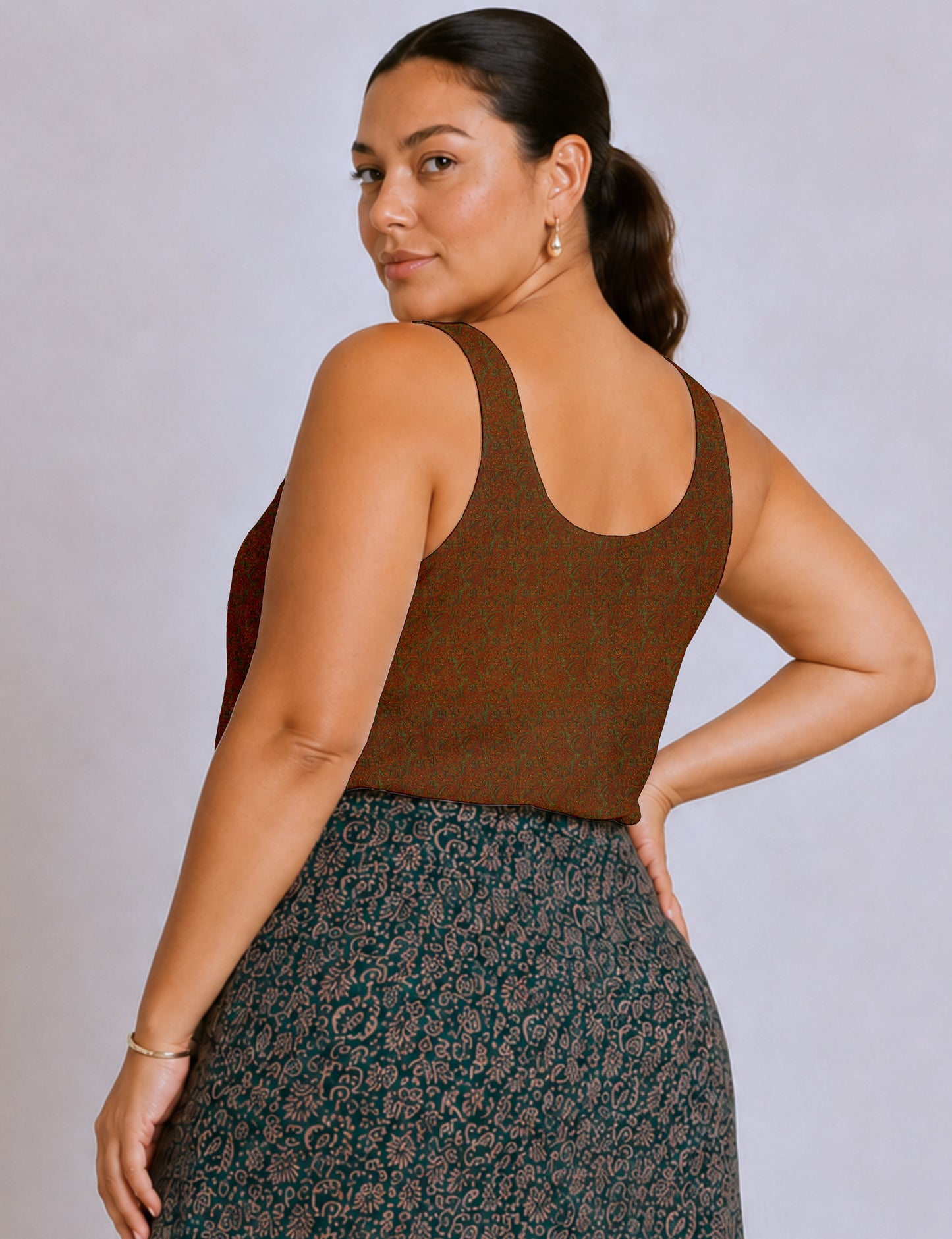 Women's sleeveless blouse with a relaxed straight fit, wide scoop neckline, deep scoop back, and hip-length silhouette.