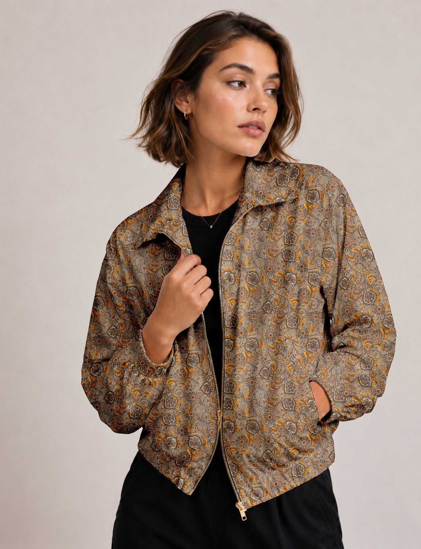 Brown floral bomber jacket with front zipper, elastic cuffs and hem, hanging on white hanger, red floral inner lining visible
