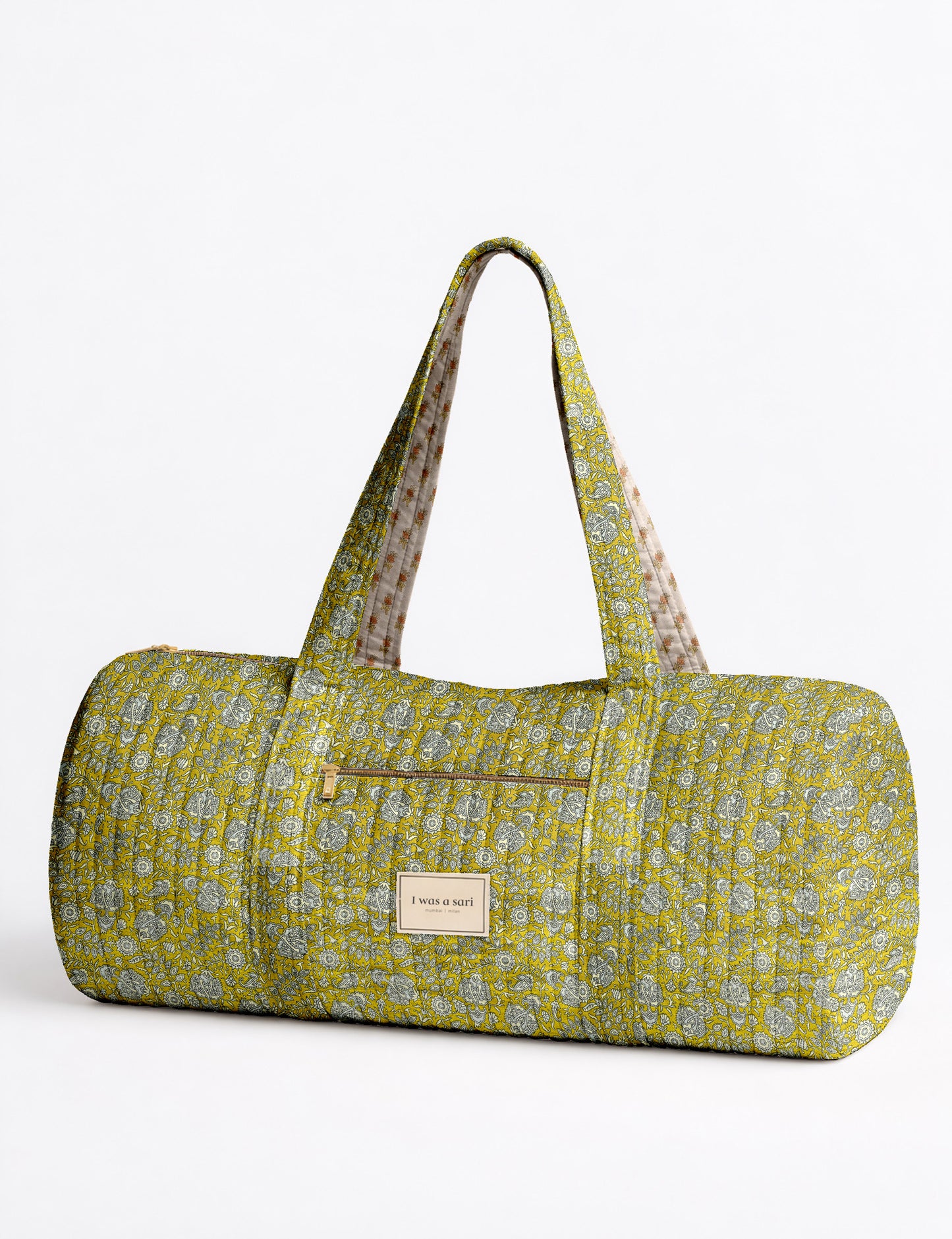 Brown paisley quilted bowling bag with dual handles, front zipper pocket, and "I was a sari" label on front side