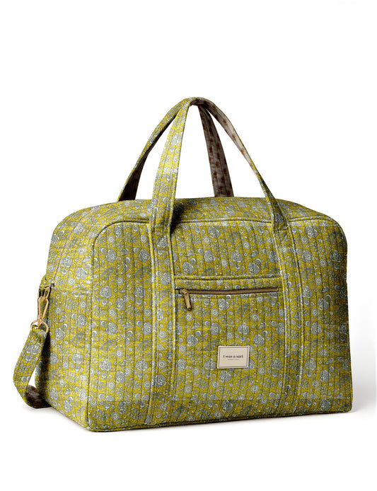 Brown quilted duffle bag with paisley pattern, front zip pocket, dual handles, and label reading "I was a sari"