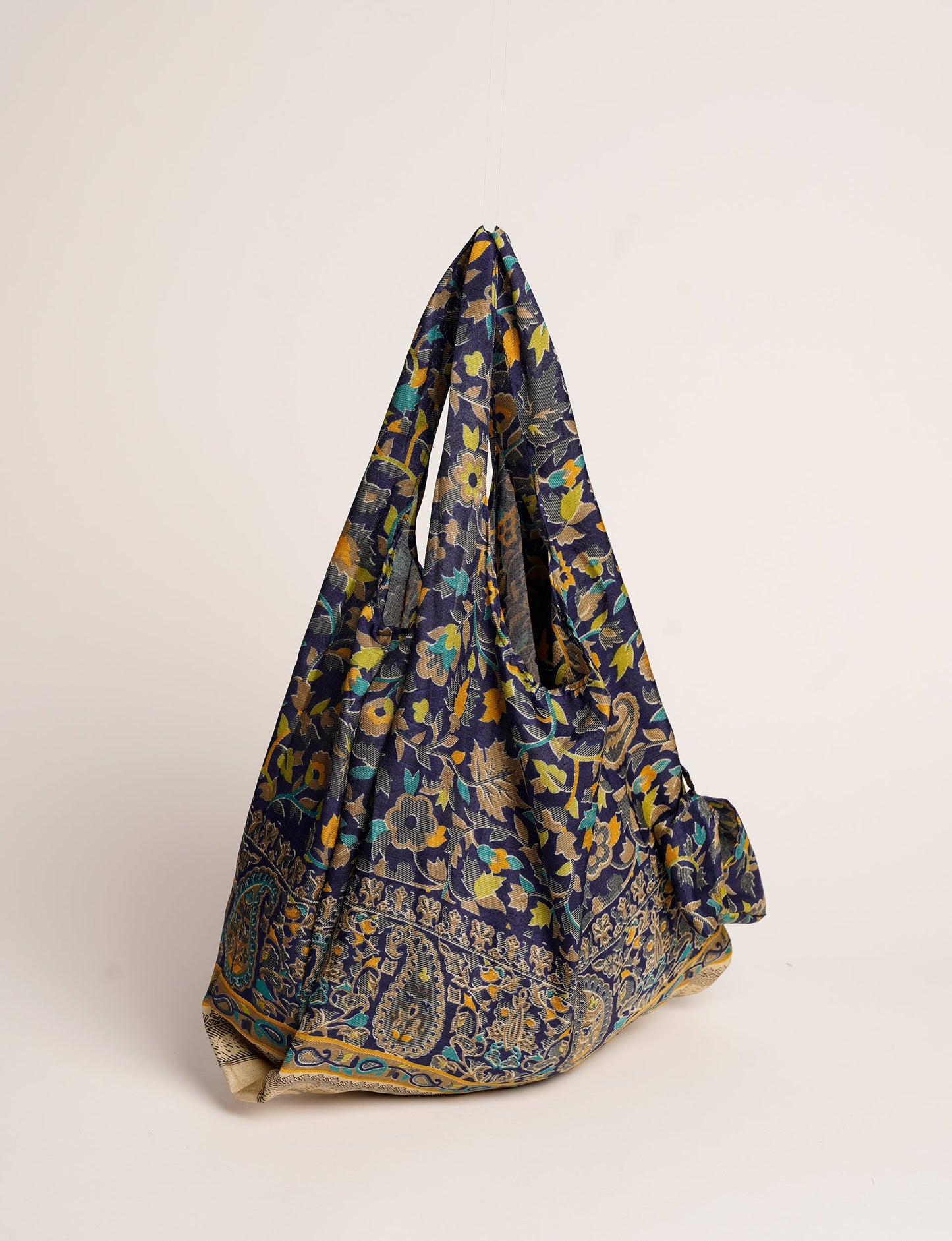 Stay eco-conscious with our Reusable Bag, handmade by Indian artisans from pre-loved saris. Silky and lightweight, this foldaway bag is perfect for your on-the-go lifestyle. Each piece is a unique statement of ethical fashion, embracing sustainability and style.