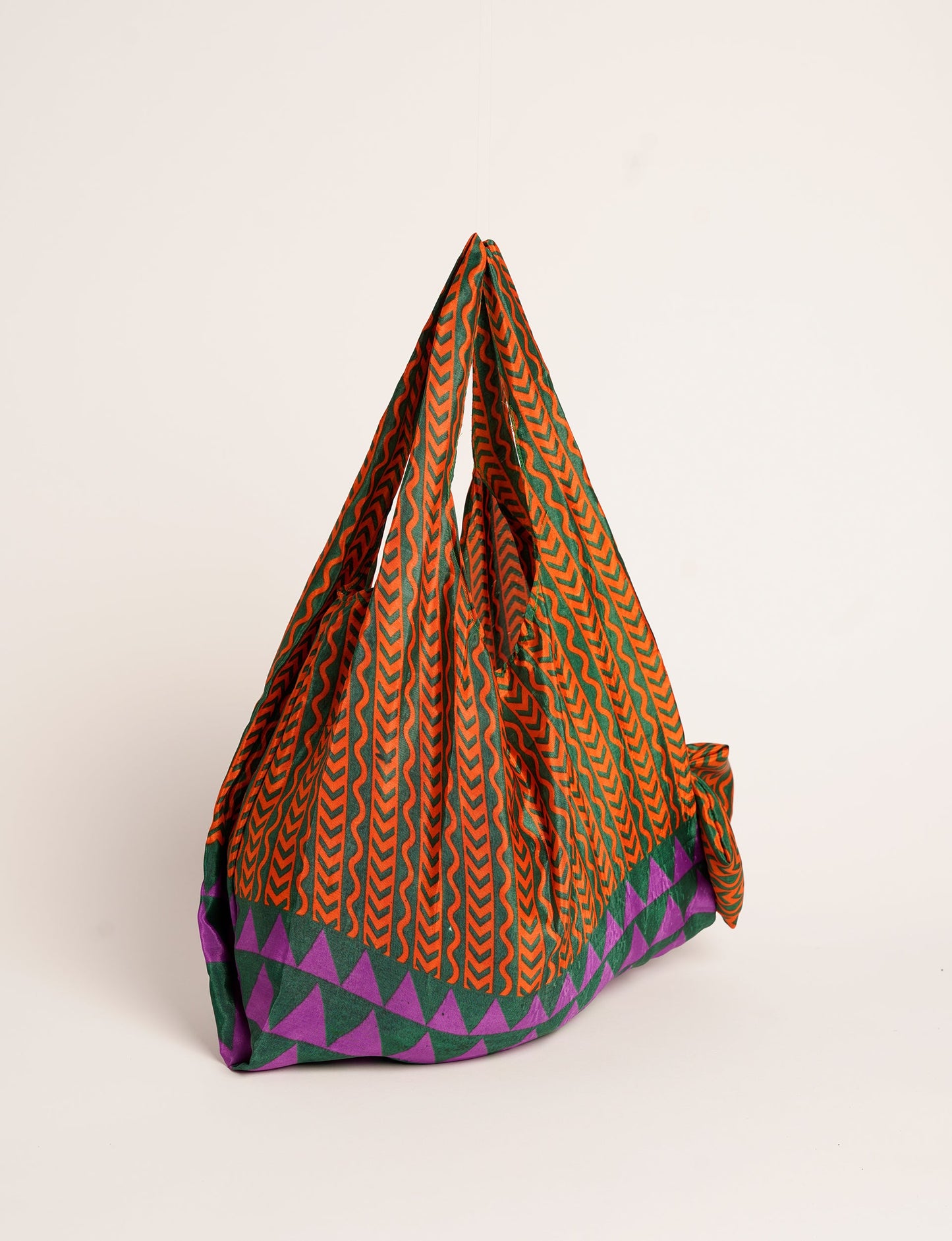 Stay eco-conscious with our Reusable Bag, handmade by Indian artisans from pre-loved saris. Silky and lightweight, this foldaway bag is perfect for your on-the-go lifestyle. Each piece is a unique statement of ethical fashion, embracing sustainability and style.