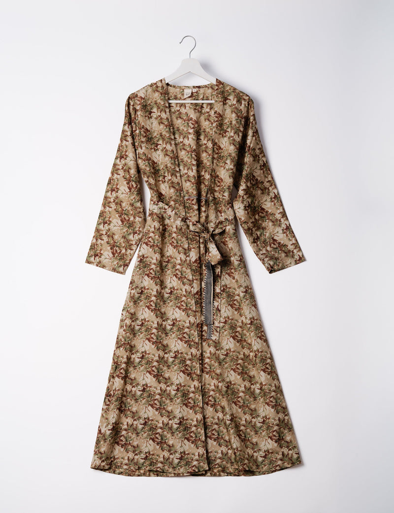 Brown abstract patterned long-sleeve beach robe with belt, hanging on white hanger against white background