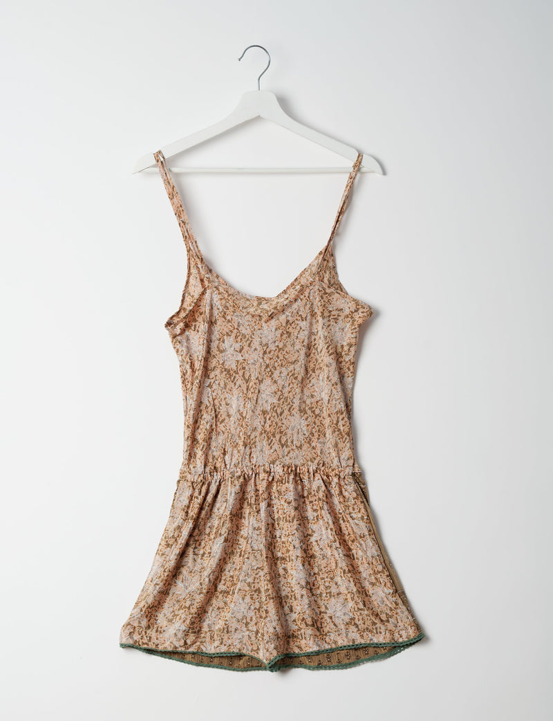 Beige floral playsuit with lace trim at hem, adjustable spaghetti straps, and gathered waist, hanging on white hanger